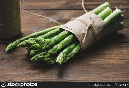 Bunch of fresh raw asparagus on a wooden brown board, a healthy product