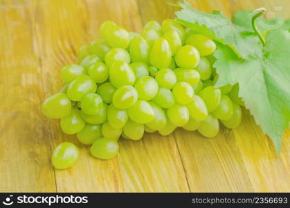Bunch of grapes on wooden table. Grapes on wooden vintage table . Ripe white grapes