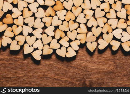 Bunch of little wooden hearts on wooden background. Valentine’s Day. Love concept.. Little hearts on wooden background.
