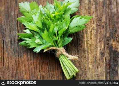 Bunch of lovage herb on wooden background .. Bunch of lovage herb on wooden background