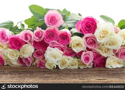 bunch of pink  and white roses on wooden table  border isolated on white background. pink and white  roses 