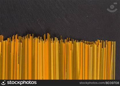 Bunch of raw italian pasta with vegetable dye of spinach, paprika and carrot