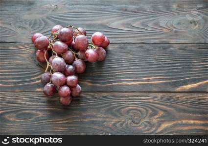 Bunch of red grape on the wooden background