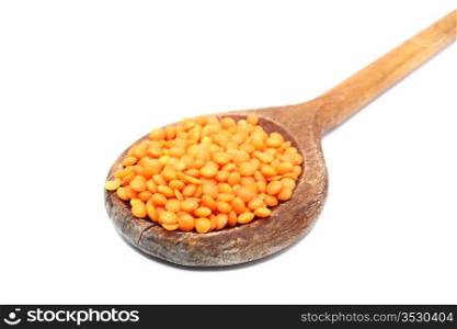 bunch of red lentil in old spoon over white
