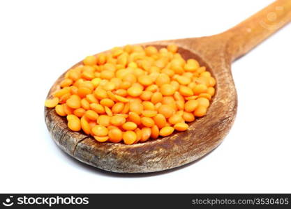 bunch of red lentil in wooden spoon over white