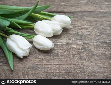 Bunch of spring tulips on an old board.