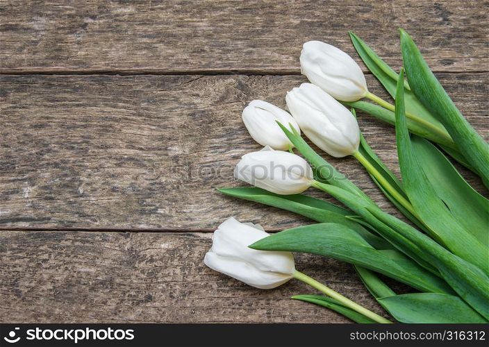 Bunch of spring tulips on an old board.