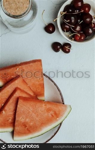 Bunch of summer and fresh fruits over a minimalist white table, watermelon and cherry, wellness and healthy food concepts, tasty , textured, copy space