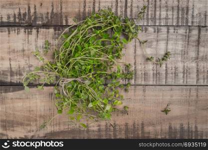 Bunch of thyme on old wooden board. Top view with copy space