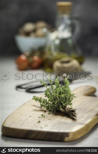 bunch of thyme, scissors and cooking ingredients on grey concrete background - Healthy food and cooking concept