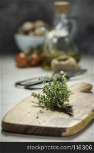 bunch of thyme, scissors and cooking ingredients on grey concrete background - Healthy food and cooking concept