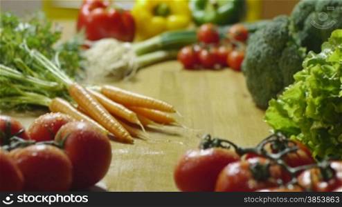 Bunch of wet tomatoes, pepper, carrots, broccoli and other vegetables on kitchen table. Dolly shot, sequence