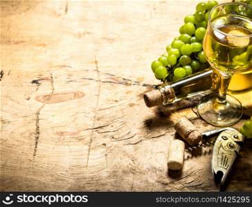 Bunch of white grapes with wine, a corkscrew and stoppers. On wooden background.. Bunch of white grapes with wine, a corkscrew and stoppers.