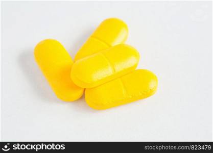 bunch of yellow capsules on white background. bunch of capsules on white background