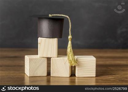 bunch wooden cubes with graduation cap