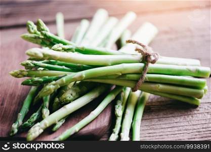 Bundle of fresh green asparagus on a rustic wooden table, asparagus bunch for cooked food