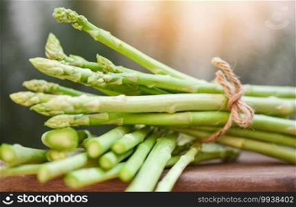 Bundle of fresh green asparagus on a rustic wooden table, asparagus bunch for cooked food