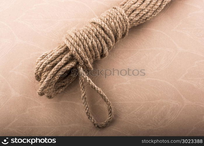 Bundle of linen rope in a sbrown background