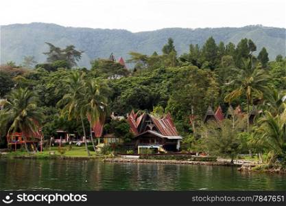 Bungalows and palm trees on the Samosir island, Indonesia
