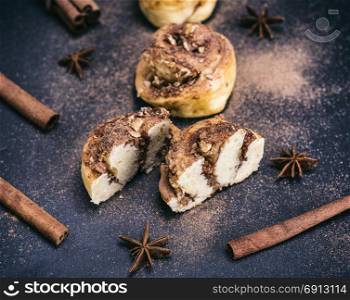 buns with cinnamon and nuts on a black background, baking powder sprinkled with ground cinnamon