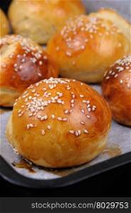 Buns with sesame in a pan just out of the oven