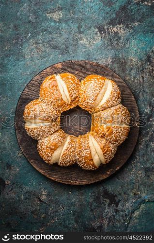 Buns with sesame on dark rustic background, top view