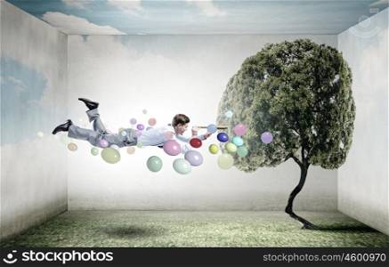 Buoyant and happy. Businessman flying in sky among balloons and looking in spyglass