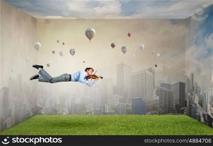 Buoyant and happy. Businessman flying in sky and playing violin