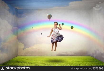 Buoyant and happy. Little cute cheerful girl in room jumping high