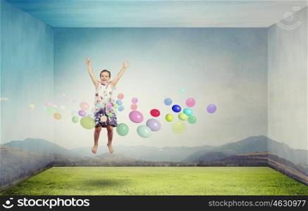 Buoyant and happy. Little cute girl jumping high among balloons flying in sky