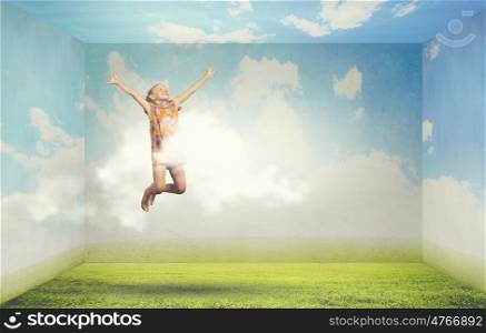 Buoyant and happy. Little cute happy girl jumping high in sky