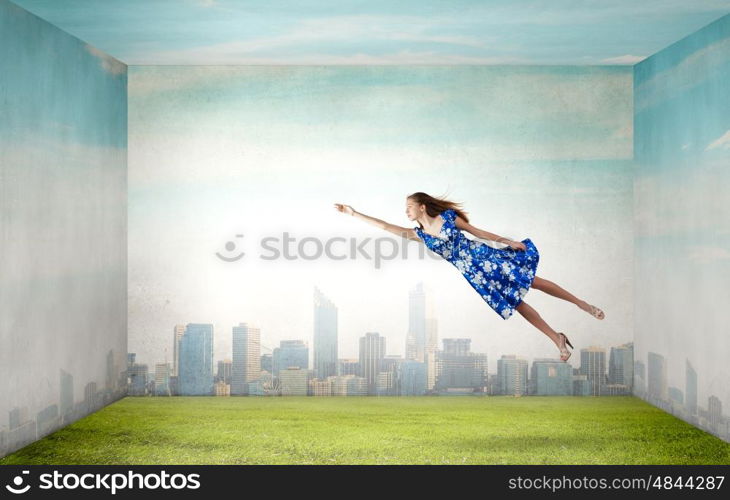 Buoyant and happy. Young woman in summer dress flying in sky