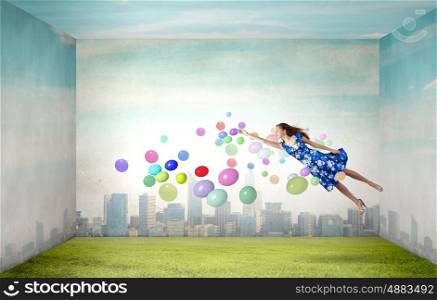 Buoyant and happy. Young woman in summer dress flying in sky