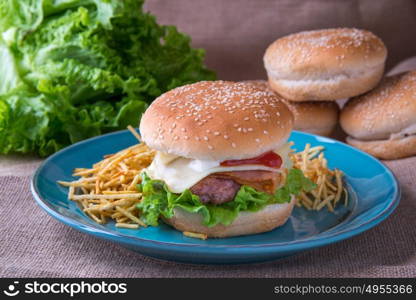 burger with cheese ham lettuce mayonnaise ketchup and chips