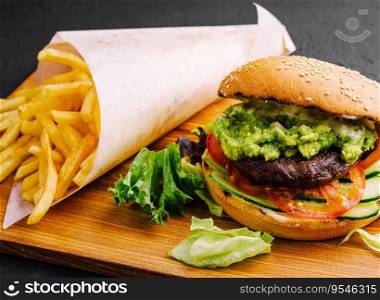 Burger with french fries on wooden tray