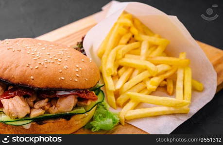 Burger with fries on wooden rustic Board