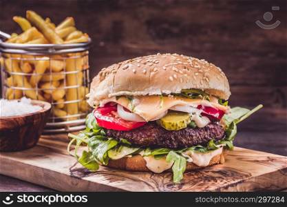 Burger with fries on wooden underground