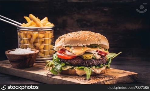 Burger with fries on wooden underground