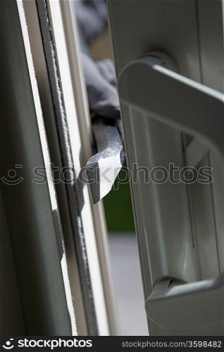 Burglar breaking into house, close-up of crowbar