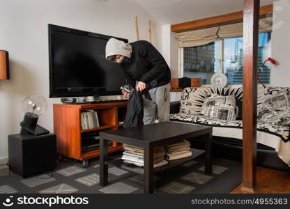 burglar robbing a house. Burglar stealing stuff in a living room
