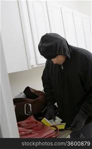 Burglar stealing money from house, close-up