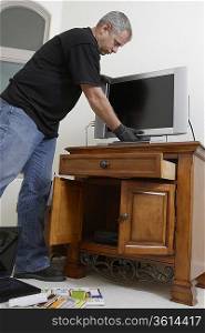 Burglar stealing television in house