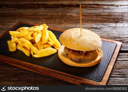 Burguer and french fries potato chips on wood table