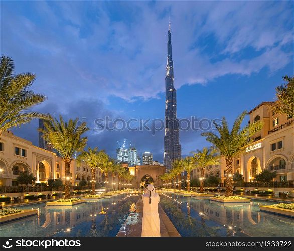 Burj Khalifa and palm trees in Palace Downtown, Dubai skyline, United Arab Emirates or UAE. Financial district and business area in smart urban city. Skyscraper and high-rise buildings.
