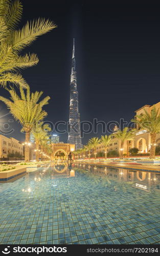 Burj Khalifa and palm trees in Palace Downtown, Dubai skyline, United Arab Emirates or UAE. Financial district and business area in smart urban city. Skyscraper and high-rise buildings.