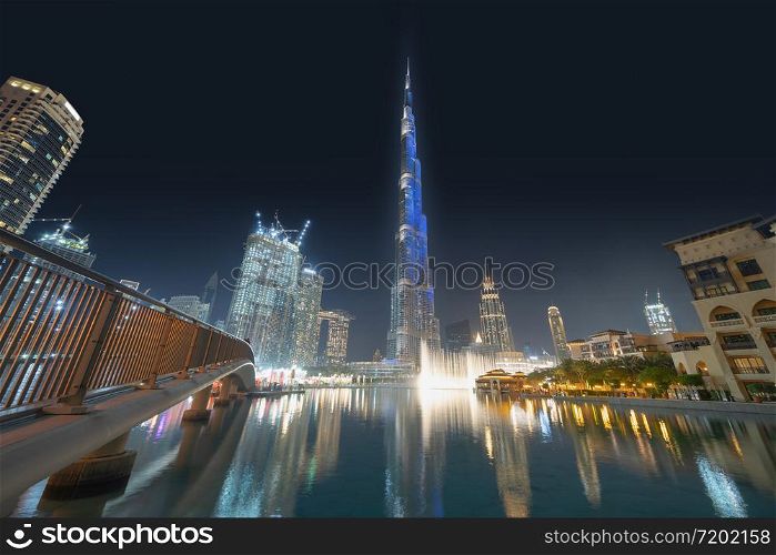 Burj Khalifa in Dubai Downtown skyline and fountain, United Arab Emirates or UAE. Financial district and business area in smart urban city. Skyscraper and high-rise buildings at sunset.