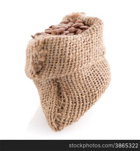Burlap bag with lentils and wooden scoop on white background.