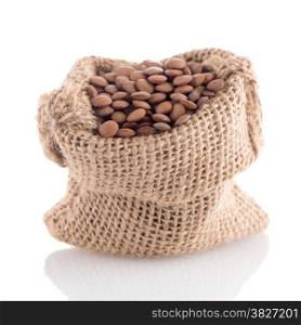 Burlap bag with lentils on white background.