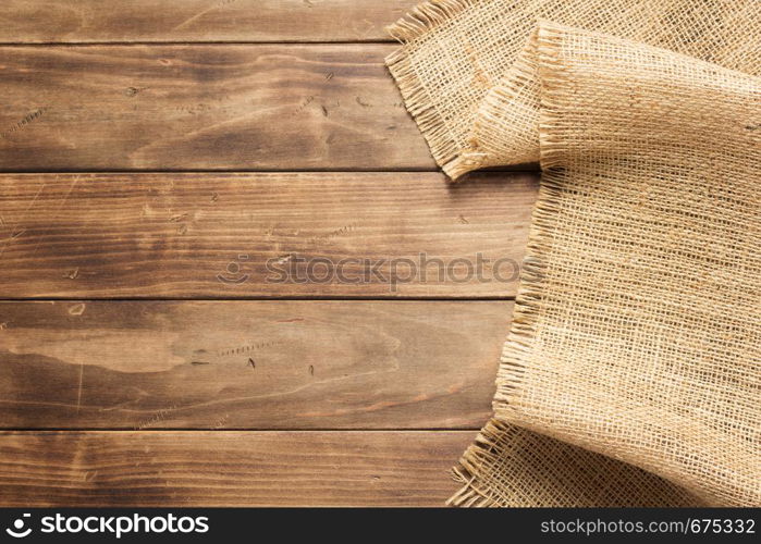 burlap hessian sacking on wooden background table, top view