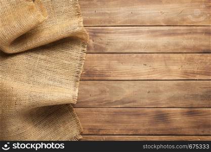 burlap hessian sacking on wooden background table, top view